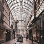 Elegant indoor view of a modern shopping mall with a stunning glass ceiling and luxury stores.