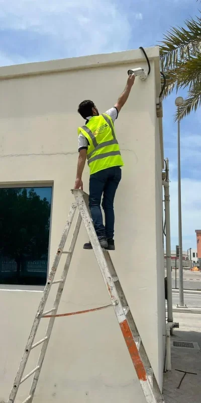 SEFA Technician installing a CCTV security camera on a building exterior