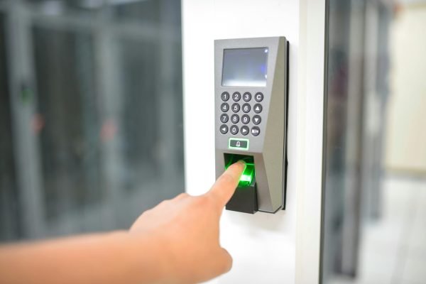 pexels-photo-17155842-17155842 A person uses a fingerprint scanner for secure entry in a business setting.