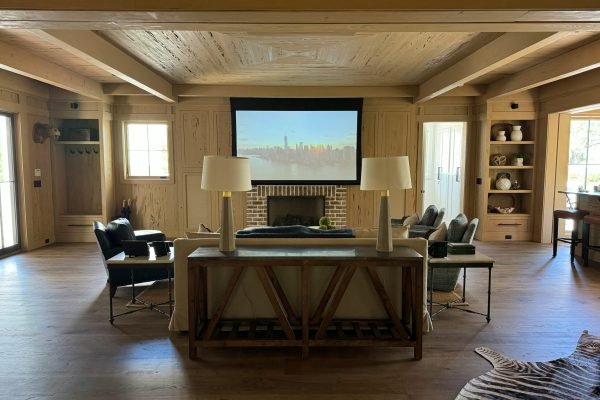 pexels-photo-30647348-30647348 Stylish living room with projector screen, cozy seating, and wooden décor.
